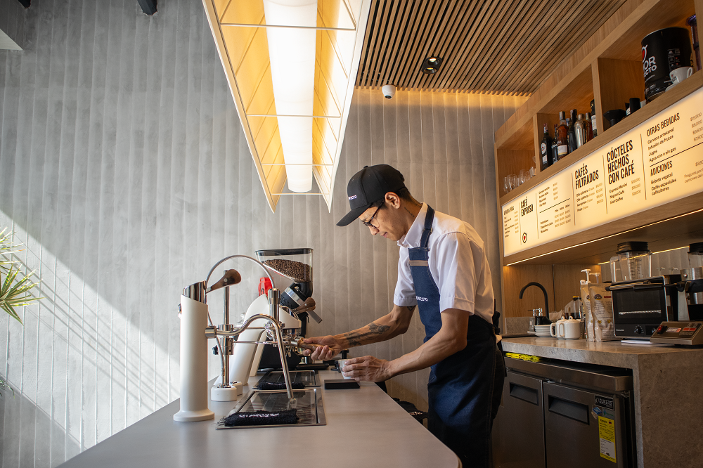 Barista de Amor Perfecto preparando café de especialidad en la tienda Nogal de Bogotá, usando máquinas de espresso profesionales.