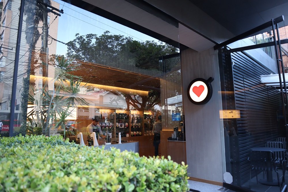 Fachada exterior de la tienda de café de especialidad Amor Perfecto en el barrio El Nogal, Bogotá. Experiencia premium de café colombiano con diseño arquitectónico moderno y barra de barismo.